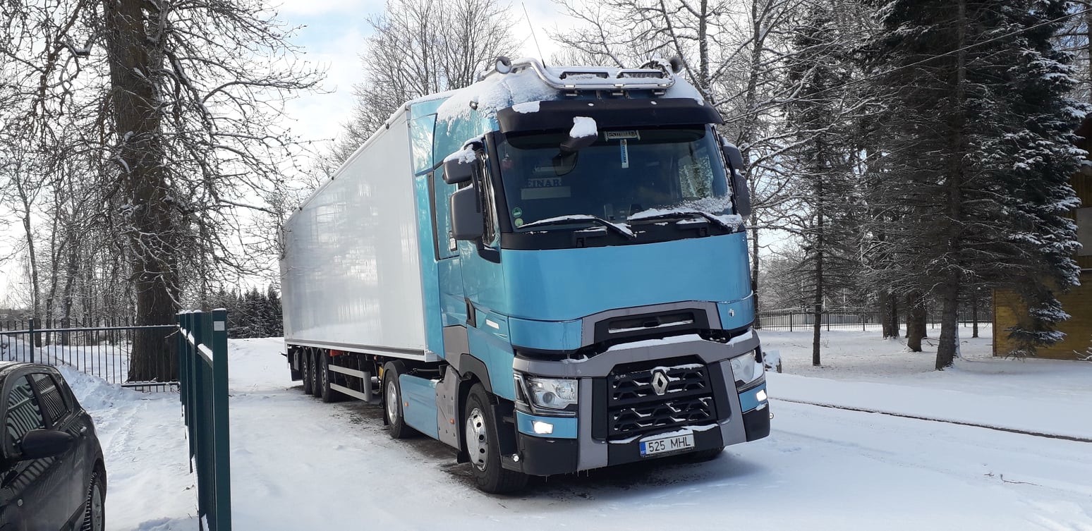 Sinine Renault T poolhaagisega talvisel teel